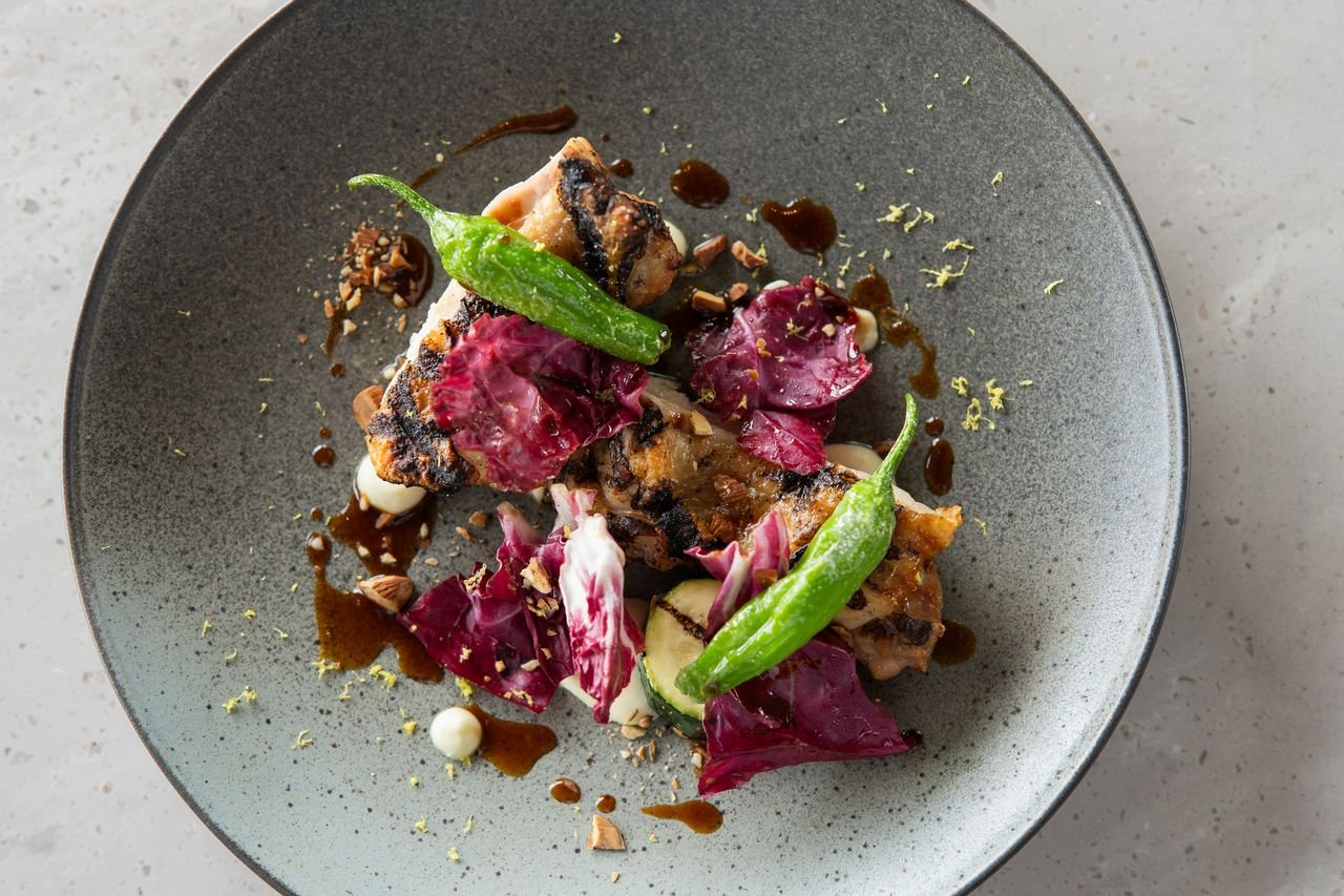 Mastering the First Impression: Your intriguing post title goes here Artisan grilled dish topped with shishito peppers and radicchio, elegantly plated in a Tokyo restaurant.